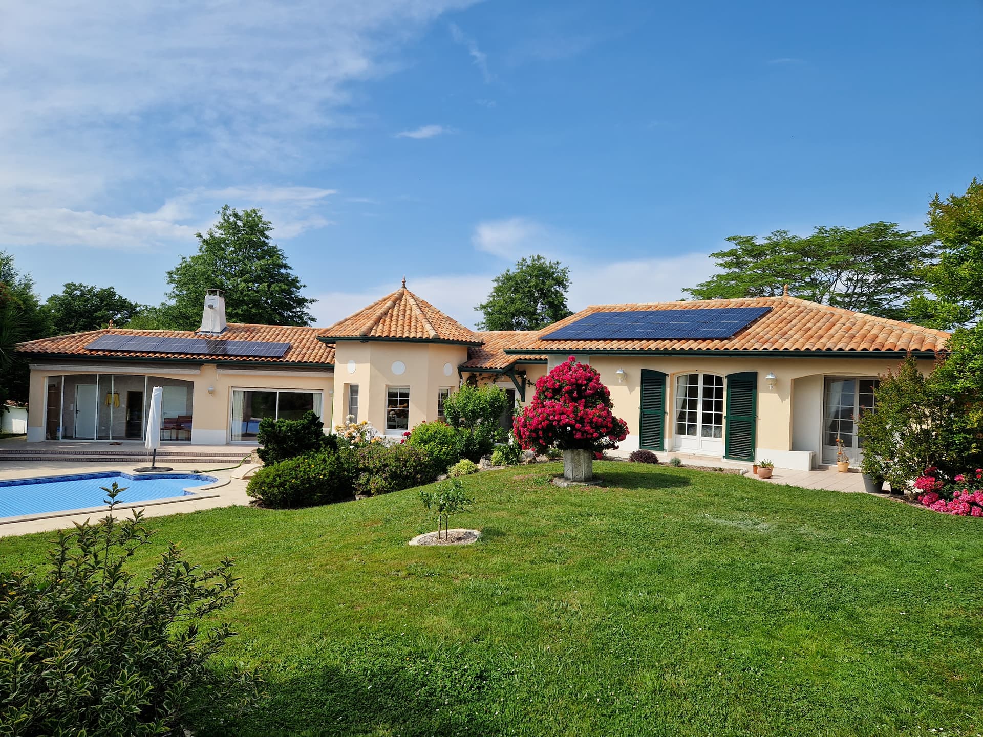 Maison avec panneaux solaires en toiture et piscine